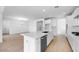 A contemporary kitchen with white cabinets, stainless steel appliances, a center island, and an open layout to the living space at 16810 W Yucatan Dr, Surprise, AZ 85388