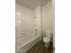 Clean, white bathroom featuring a tub and shower combo, complemented by wood-look tile flooring at 1730 W Pollack St, Phoenix, AZ 85041