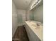 Bathroom with double sink vanity, wood-look tile floors, and a shower with glass doors at 1730 W Pollack St, Phoenix, AZ 85041