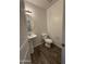 Powder room with pedestal sink, wood-look tile flooring, and white toilet at 1730 W Pollack St, Phoenix, AZ 85041