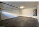 A clean garage featuring concrete flooring, white walls, garage door, and a hot water heater at 1730 W Pollack St, Phoenix, AZ 85041