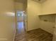 Bright laundry room featuring wood-look tile floors, storage shelving, and washer/dryer hookups at 1730 W Pollack St, Phoenix, AZ 85041