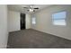 Spacious bedroom featuring plush carpeting, a ceiling fan, and natural light from multiple windows at 1738 W Pollack St, Phoenix, AZ 85041