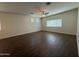 Spacious living area featuring wood-look tile flooring, ceiling fan, and natural light from multiple windows at 1738 W Pollack St, Phoenix, AZ 85041