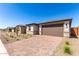 Charming single-story home featuring stone accents, a brown garage door, and a brick paver driveway at 18486 E Dario Rd, Gold Canyon, AZ 85118