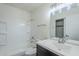 Bright bathroom featuring a white vanity, shower-tub combo, and a mirrored closet at 1961 N Hartford St # 1055, Chandler, AZ 85225