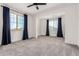 Bright living room featuring neutral walls, plush carpeting, lots of light, and a modern ceiling fan at 20451 E Via De Colina --, Queen Creek, AZ 85142