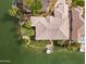 Overhead shot of sprawling lakeside home, showcasing tile roof, lush landscaping, and private boat dock at 2128 E Clipper Ln, Gilbert, AZ 85234