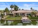 Beautiful waterfront home with lush landscaping, boat dock, and patio overlooking the serene lake at 2128 E Clipper Ln, Gilbert, AZ 85234