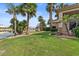 Well-maintained backyard with lush lawn, palm trees, and access to a peaceful lake, ideal for relaxation at 2128 E Clipper Ln, Gilbert, AZ 85234
