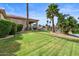 Beautiful backyard with lush green lawn, mature trees, and waterfront access to a tranquil lake at 2128 E Clipper Ln, Gilbert, AZ 85234