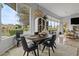 Dining area with water views, wood table, seating for six, and built-in cabinet and open to living area at 2128 E Clipper Ln, Gilbert, AZ 85234