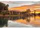 Waterfront home at sunset with lush landscaping and a boat dock for enjoying the serene lake at 2128 E Clipper Ln, Gilbert, AZ 85234