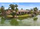 Waterfront home with tile roof, lush landscaping, and a boat dock for enjoying the serene lake at 2128 E Clipper Ln, Gilbert, AZ 85234