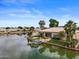 Beautiful waterfront home with lush green lawn and private boat dock on a sunny day at 2128 E Clipper Ln, Gilbert, AZ 85234