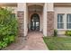 Inviting front entrance with stone walkway, custom wrought iron doors, and manicured greenery at 2128 E Clipper Ln, Gilbert, AZ 85234