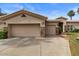 Spacious three-car garage with stone accents and a well-maintained driveway in a well-kept community at 2128 E Clipper Ln, Gilbert, AZ 85234