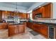 Traditional-style kitchen features wood cabinets, dark countertops, wine cooler, and a decorative tile backsplash at 2128 E Clipper Ln, Gilbert, AZ 85234