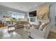Spacious living room with a cozy fireplace, large windows, and views of the lake at 2128 E Clipper Ln, Gilbert, AZ 85234