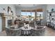 Cozy living room with a fireplace, plush seating, and expansive windows offering picturesque waterfront views at 2128 E Clipper Ln, Gilbert, AZ 85234
