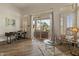 Bright living room with a modern desk area, patio access and beautiful wood flooring at 2128 E Clipper Ln, Gilbert, AZ 85234