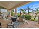 Covered patio with comfortable seating, offering views of the lush landscaping and lake at 2128 E Clipper Ln, Gilbert, AZ 85234