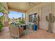 Covered patio with comfortable seating, offering views of the lush landscaping and lake at 2128 E Clipper Ln, Gilbert, AZ 85234