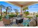Covered patio with comfortable seating, offering views of the lush landscaping and lake at 2128 E Clipper Ln, Gilbert, AZ 85234