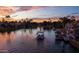 Sunset view of boats cruising along a scenic waterway lined with palm trees and luxury homes at 2128 E Clipper Ln, Gilbert, AZ 85234