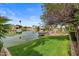 Beautiful waterfront property with a boat dock, lush green lawn, and mature trees, creating a serene retreat at 2128 E Clipper Ln, Gilbert, AZ 85234