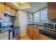 Efficient kitchen featuring wood cabinets, stainless steel appliances, and natural light from a window above the sink at 2228 N 52 St # 213, Phoenix, AZ 85008