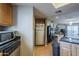 Open-concept kitchen showcasing a mix of wood cabinetry and stainless steel appliances with breakfast bar at 2228 N 52 St # 213, Phoenix, AZ 85008