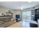 Comfortable living room featuring a sofa, TV, shelving, and sliding glass doors to a balcony at 2228 N 52 St # 213, Phoenix, AZ 85008