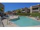 Sparkling community pool surrounded by lounge chairs, complemented by the view of well-kept condo buildings at 2228 N 52 St # 213, Phoenix, AZ 85008