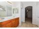 Well lit bathroom with double sink, vanity, tile floor, and entry to Primary bedroom at 2475 E Vermont Dr, Gilbert, AZ 85295