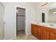 Bathroom featuring double sinks, wood cabinets, and a walk-in closet for plenty of storage at 2475 E Vermont Dr, Gilbert, AZ 85295