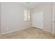 An empty bedroom with window, tile floor, closet, and neutral color scheme at 2475 E Vermont Dr, Gilbert, AZ 85295