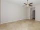 Cozy bedroom with neutral walls, tile floors, ceiling fan, and a doorway leading to another room at 2475 E Vermont Dr, Gilbert, AZ 85295