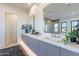 Double vanity bathroom with large mirrors, stylish tiling, and modern fixtures at 25564 N 119Th St, Scottsdale, AZ 85255
