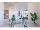 Bright open-concept space featuring a modern glass desk and a view into the bedroom at 25564 N 119Th St, Scottsdale, AZ 85255