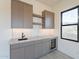Close up of wet bar featuring custom cabinets, marble countertops, a sink, and a wine cooler at 25564 N 119Th St, Scottsdale, AZ 85255