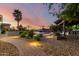 Beautiful backyard with a pool, waterfall, covered patio, lush landscaping, and stone paver walkway at 2892 E Fruitvale Ave, Gilbert, AZ 85297