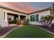 Well-maintained backyard featuring manicured synthetic grass, mature trees, and elegant pillars around the patio area at 2892 E Fruitvale Ave, Gilbert, AZ 85297