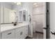 Well-lit bathroom with a white vanity, dual mirrors, and a view into the tiled shower at 2892 E Fruitvale Ave, Gilbert, AZ 85297