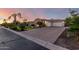 Lovely home with a brick driveway and attached garage with white garage doors framed by lush, mature landscaping at 2892 E Fruitvale Ave, Gilbert, AZ 85297
