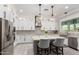 Modern kitchen featuring white cabinets, stainless steel appliances, island with seating, and granite countertops at 2892 E Fruitvale Ave, Gilbert, AZ 85297