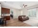 Inviting living room with a leather sofa, wood floors, ceiling fan, and natural light from a large window at 2892 E Fruitvale Ave, Gilbert, AZ 85297