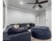 Bright living room with a large sectional sofa, neutral colors, and modern ceiling fan at 2892 E Fruitvale Ave, Gilbert, AZ 85297