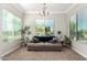 Cozy living room with a comfortable sofa and plenty of natural light from the large windows at 2892 E Fruitvale Ave, Gilbert, AZ 85297