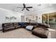 Inviting living room features a large leather sectional sofa, ceiling fan, and a view into the kitchen at 2892 E Fruitvale Ave, Gilbert, AZ 85297